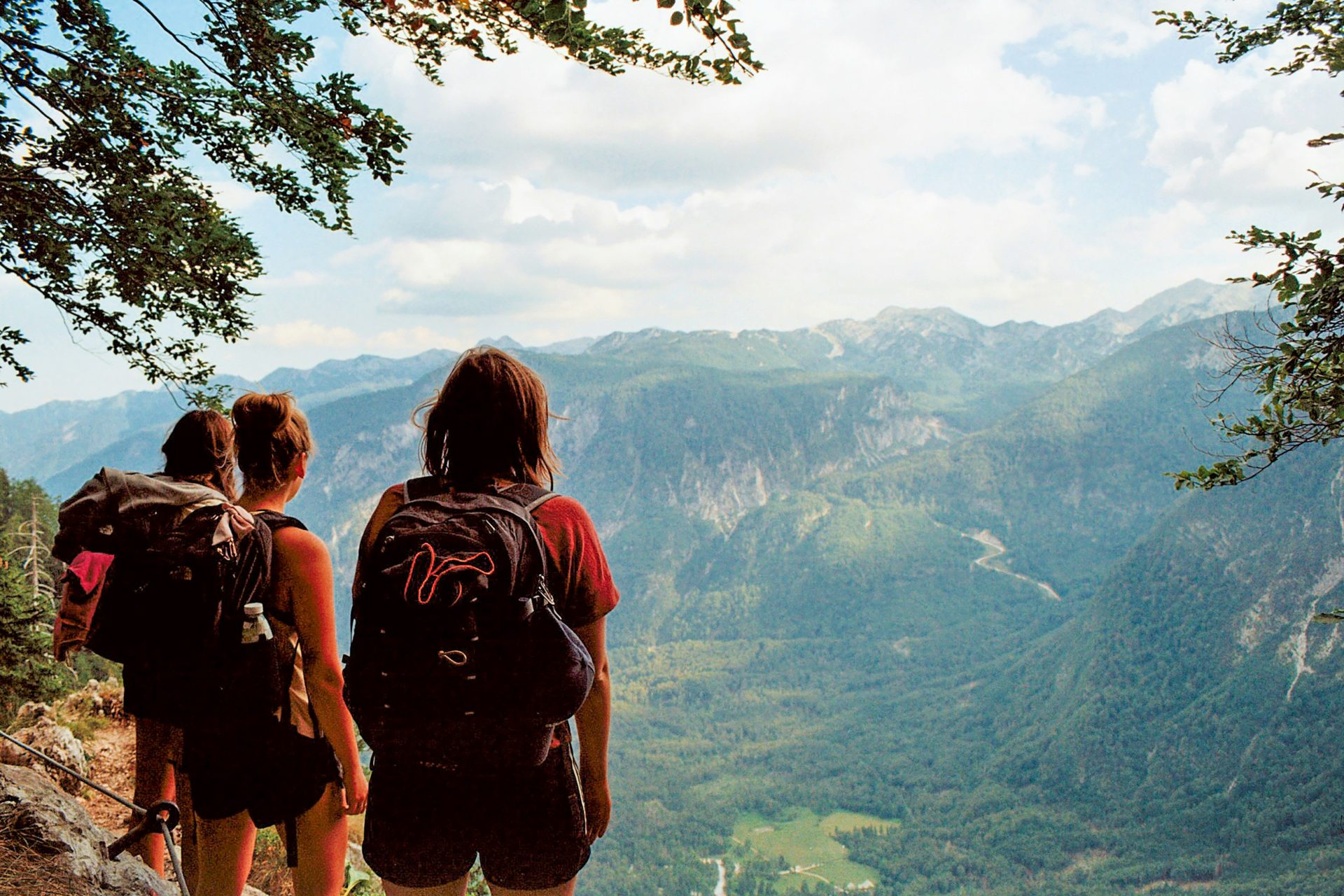 a couple of people standing on top of a mountain