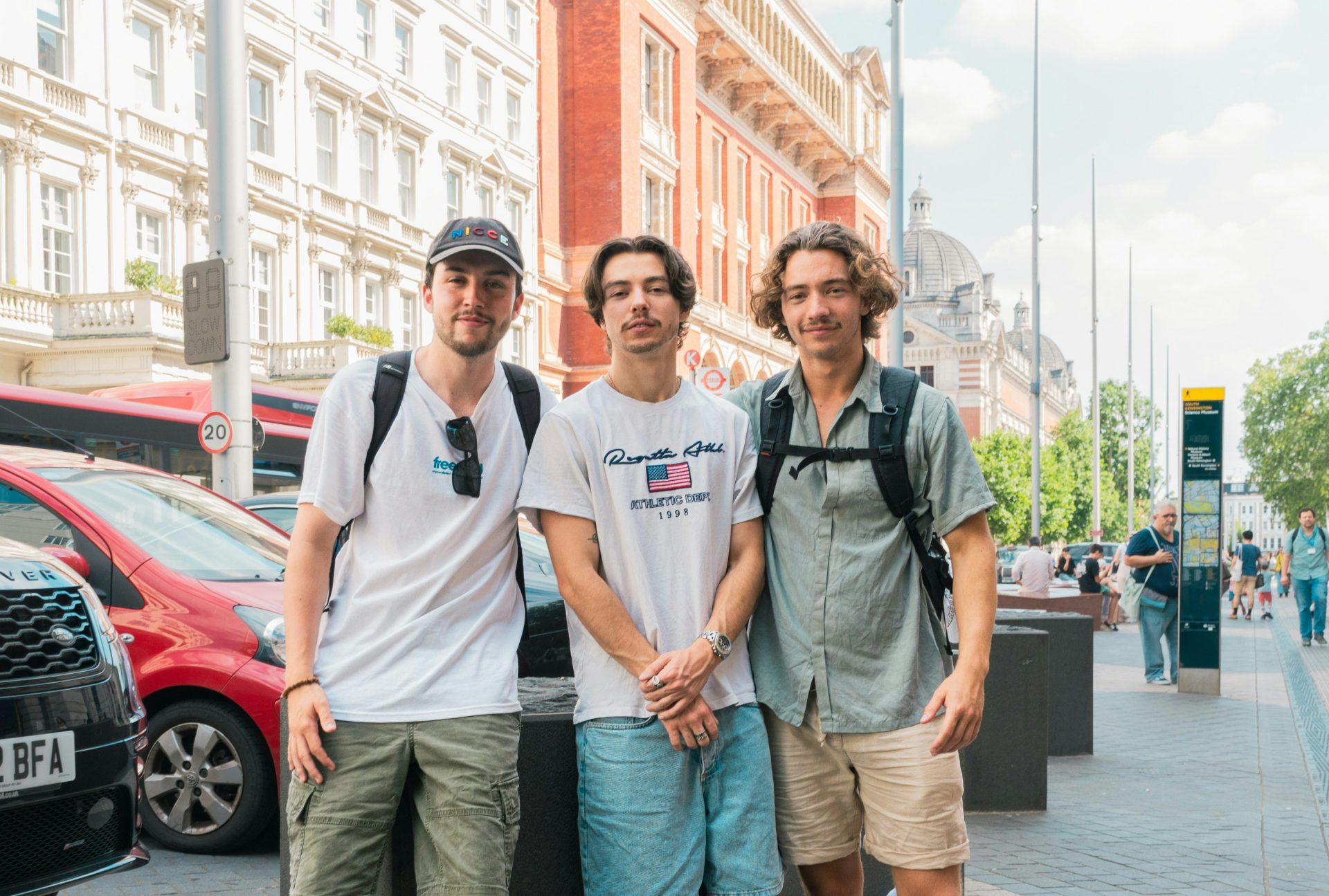 A group of young men standing next to each other on a sidewalk